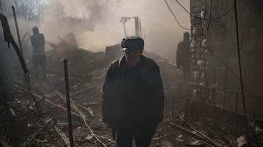 A man walks amid smoke from a burning house, destroyed after a Russian attack in Kharkiv, Ukraine, Thursday, March 24, 2022. (AP Photo/Felipe Dana)
