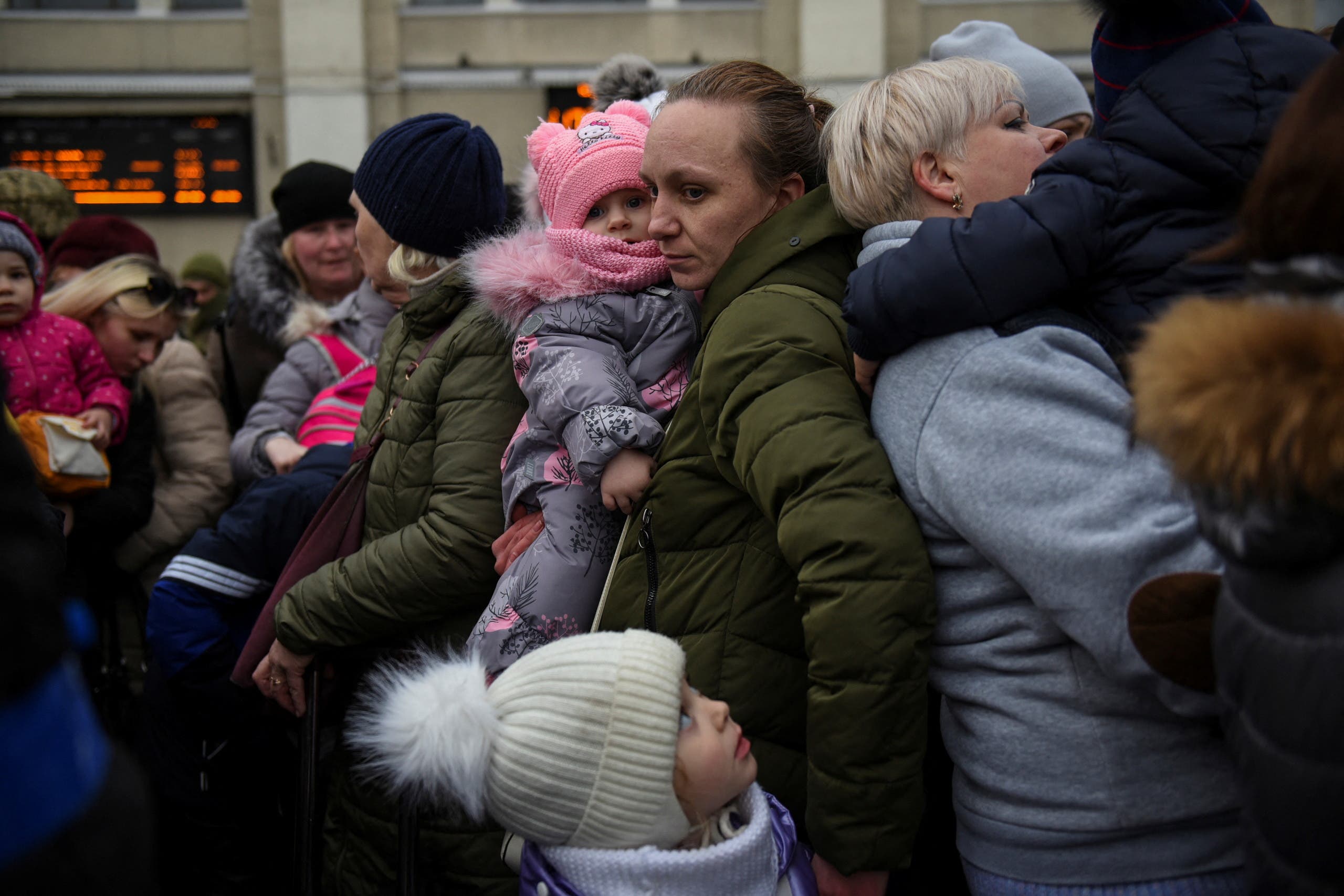 سيدة تحمل طفلةً تنتظر لتستقل القطار هرباً من أوديسا