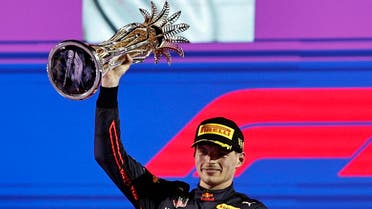 Red Bull’s Max Verstappen celebrates on the podium with the trophy after winning the Saudi Arabia Grand Prix race in Jeddah on March 27, 2022. (Reuters)