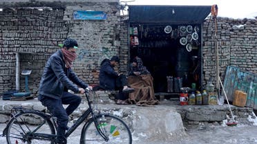 An Afghan man rides his cycle past a shop selling fuel in Kabul, Afghanistan. (Reuters)