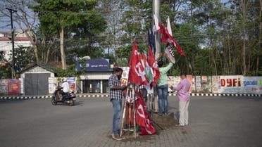 Strike supporters erect flags at a traffic intersection on the first day of two day nationwide strike called by various labor unions in Kochi, Kerala state, India, Monday, March 28, 2022. Workers have called for strike to express their anger at the government’s economic policies and to back demands for their improved rights. (AP)