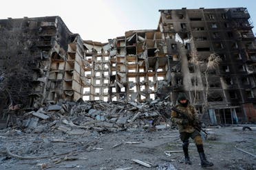 A service member of pro-Russian troops walks near an apartment building destroyed in the course of Ukraine-Russia conflict in the besieged southern port city of Mariupol, Ukraine March 28, 2022. (Reuters)