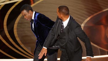 FILE PHOTO: Will Smith (R) hits Chris Rock as Rock spoke on stage during the 94th Academy Awards in Hollywood, Los Angeles, California, U.S., March 27, 2022. REUTERS/Brian Snyder/File Photo