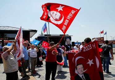 أنصار للحزب الحاكم في تركيا يرفعون صور أرلادوغان خلال تكع انتخابي ليلدرم في اسطننبول في 2019