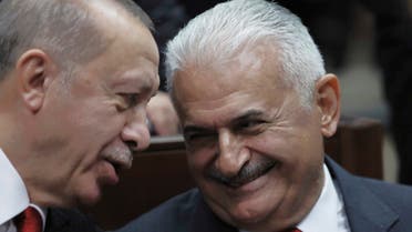 Turkish President Recep Tayyip Erdogan, left, speaks with Binali Yildirim, his former last prime minister, at the Parliament, in Ankara, Tuesday, Nov. 5, 2019. Erdogan called on Russia and the United States on Tuesday to keep to their promises to ensure that Syrian Kurdish fighters pull out of Syrian borders areas with Turkey.(AP Photo/Burhan Ozbilici)