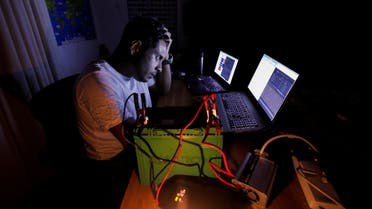 Amila Uduwerell, an IT officer who is home-based uses a car battery to charge his laptops as he works during the seven hours power outage, in Colombo, Sri Lanka, March 2, 2022. (Reuters)