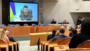 Ukrainian President Volodymyr Zelenskiy appears on screen as he addresses the members of Dutch parliament via video link, amid Russia's invasion of Ukraine, in The Hague, Netherlands, March 31, 2022. (Reuters)