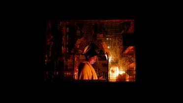 A woman works inside a shop attached to her house during the power cut in Colombo, Sri Lanka March 30, 2022. (Reuters)