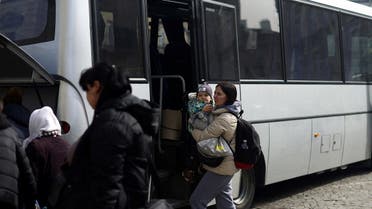 A Ukrainian refugee disembarks a bus at Przemysl Glowny train station, after fleeing the Russian invasion of Ukraine, in Przemysl, Poland, on March 27, 2022. (Reuters)                   