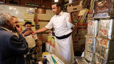 A vendor gives dates to customers to taste as Yemenis prepare for the fasting month of Ramadan in Sanaa, April 1, 2022. (Reuters)