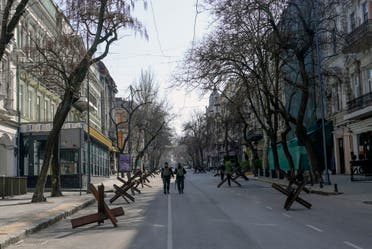 Soldiers walk in an empty street of Odesa on March 17, 2022. Odessa, which Ukraine fears could be the next target of Russia's offensive in the south, is the country's main port and is vital for its economy. But the city of one million people close to the Romanian and Moldovan borders also holds a special place in the Russian imagination. (Photo by BULENT KILIC / AFP)