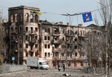 Local residents walk along a street next to a building damaged during Ukraine-Russia conflict in the southern port city of Mariupol, Ukraine April 3, 2022. The sign on the vehicle reads: Children. (Reuters)