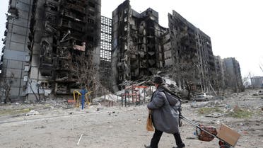 A local resident walks near an apartment building destroyed during Ukraine-Russia conflict in the southern port city of Mariupol, Ukraine April 3, 2022. REUTERS/Alexander Ermochenko