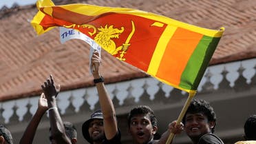 A man waves a Sri Lankan flag as people shout slogans against Sri Lanka's President Gotabaya Rajapaksa and demand that Rajapaksa family politicians step down, during a protest amid the country's economic crisis, at Independence square in Colombo, Sri Lanka, April 4, 2022. REUTERS/Dinuka Liyanawatte