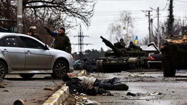 Ukrainian army soldiers drive on their tanks as the body of a civilian, who according to residents was killed by Russian army soldiers, lies in the street, amid Russia's invasion of Ukraine, in Bucha, in Kyiv region, Ukraine April 3, 2022. (Reuters)