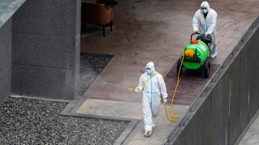 Workers in protective suit spray disinfectant at a community, during the lockdown to curb the spread of the coronavirus disease (COVID-19) in Shanghai, China, April 5, 2022. (Reuters)