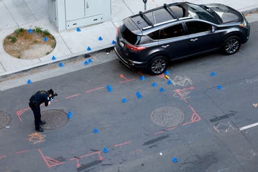 A police evidence technician photographs the crime scene after an early-morning shooting in a stretch of downtown near the Golden 1 Center arena in Sacramento, California, U.S. April 3, 2022. (Reuters)