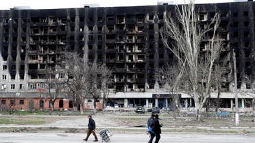 Local residents walk past a burned building during Ukraine-Russia conflict in the southern port city of Mariupol, Ukraine April 4, 2022. (File photo: Reuters)