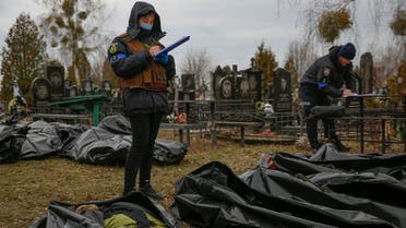 Police investigators work with bodies of civilians, collected from streets to local cemetery, as Russia's attack on Ukraine continues, in the town of Bucha, outside Kyiv, Ukraine April 6, 2022. (Reuters)
