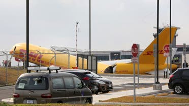 Airport personnel stand at the scene where a Boeing 757-200 cargo aircraft operated by DHL made an emergency landing before skidding off the runway and splitting, aviation aircraft said, at the Juan Santamaria International Airport in Alajuela, Costa Rica April 7, 2022. ( Reuters)