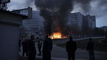 Residents stand outside their apartments as shops burn after a Russian attack in Kharkiv, Ukraine, Monday, April 11, 2022. (AP)