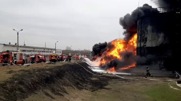This video grab taken from a handout footage released by the Russian Emergencies Ministry on April 1, 2022 shows firemen working to extinguish a fire at a Rosneft fuel depot in the town of Belgorod, some 40 kilometres (25 miles) from Russia's border with Ukraine. (AFP)