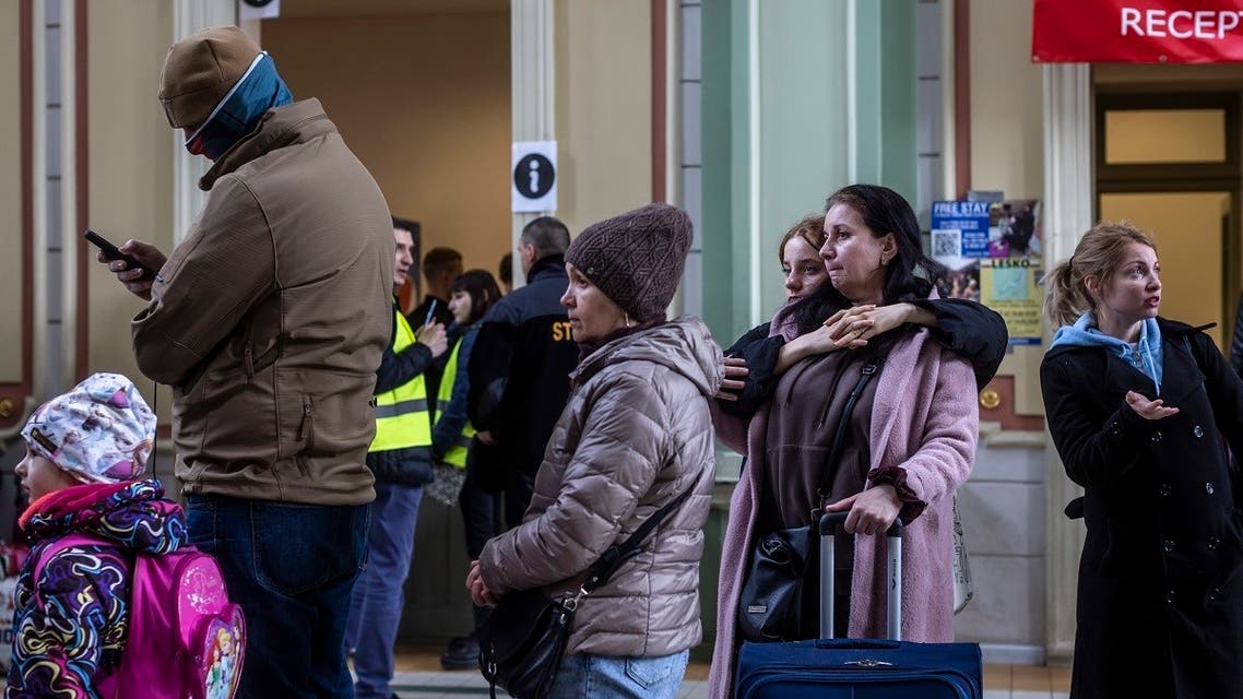 A woman and her daughter are pictured as they queue to get tickets to return to Kyiv on the railway station in Przemysl, southeastern Poland, on April 5, 2022. (AFP)