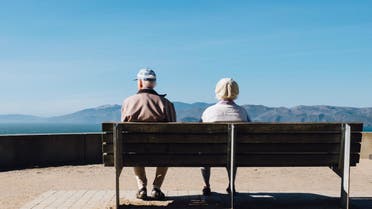 Stock image of a retired, elderly couple sitting on a bench. (Unsplash, Matt Bennett)