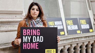 Roxanne Tahbaz, daughter of Morad Tahbaz detained in Iran, protests for the release of her father, outside of Britain's Foreign, Commonwealth and Development Office (FCDO) in central London on April 13, 2022. (AFP)