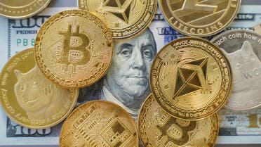 Close up shot of Bitcoin and alt coins cryptocurrency standing over a Hundred Dollar Bill. High angle view, no people stock photo
