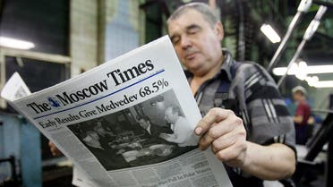 A worker from a printing plant reads a freshly printed Moscow Times newspaper, with an article about the presidential election on its front page, in Moscow March 3, 2008. (File photo: Reuters)