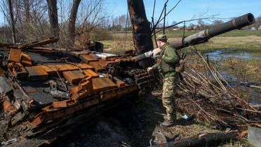 A Ukrainian service member inspects remains of a tank destroyed during Russia's invasion, in the village of Termakhivka, in Kyiv region, Ukraine April 14, 2022. (Reuters)