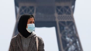 A woman, wearing a hijab and a protective face mask, walks at Trocadero square near the Eiffel Tower in Paris, France, May 2, 2021. (File photo: Reuters)