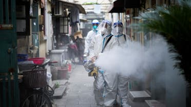 Workers in protective suits disinfect an old residential area under lockdown amid the coronavirus disease (COVID-19) pandemic, in Shanghai, China, April 15, 2022. (Reuters)
