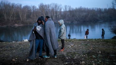 Migrants gather at Maritsa river (Evros river in Greek) in Edirne, Turkey, at the Turkish-Greek border, Monday, March 2, 2020. Thousands of migrants and refugees massed at Turkey's western frontier, trying to enter Greece by land and sea after Turkey said its borders were open to those hoping to head to Europe. (AP Photo/Emrah Gurel)