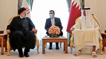 A handout picture provided by the Iranian presidency shows Qatar's Emir Sheikh Tamim bin Hamad al-Thani (R) meeting with Iranian President Ebrahim Raisi upon his arrival in Doha, on February 21, 2022. (AFP)