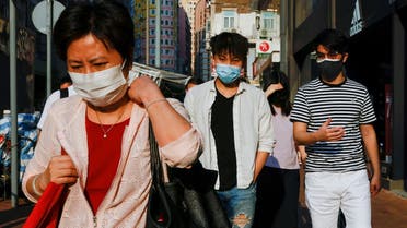 People wearing face masks walk through Wan Chai district during the coronavirus disease (COVID-19) pandemic, in Hong Kong, China, April 14, 2022. (Reuters)