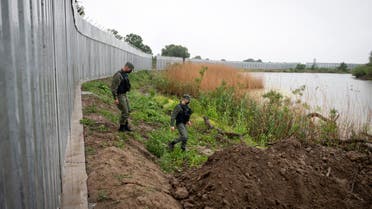 FILE - In this Friday, May 21, 2021, policemen patrol alongside a steel wall at Evros river, near the village of Poros, at the Greek - Turkish border, Greece. Greece says it will renew a request for European Union funds in 2022 to extend a border wall along its frontier with Turkey and promised to expand a powerful surveillance network aimed at stopping migrants entering the country illegally. (AP Photo/Giannis Papanikos, File)
