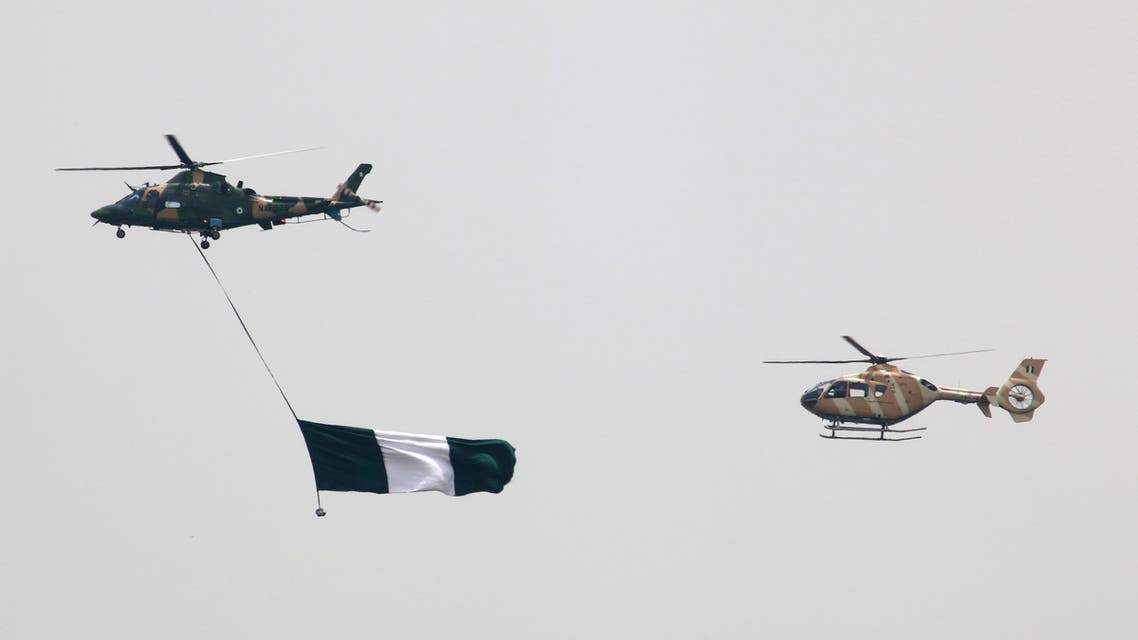 Nigerian Air Force helicopters perfom with the flag of Nigeria during a parade marking the country's 58th anniversary of independence, on October 1, 2018, on Eagle Square in Abuja. (Photo by Sodiq ADELAKUN / AFP)
