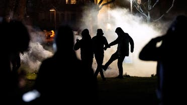Protesters stand amid tear gas fired by the police in Rosengard district, following Quran burnings that caused riots in several Swedish towns over the Easter weekend, in Malmo, Sweden April 18, 2022. Johan Nilsson/TT News Agency/via REUTERS ATTENTION EDITORS - THIS IMAGE WAS PROVIDED BY A THIRD PARTY. SWEDEN OUT. NO COMMERCIAL OR EDITORIAL SALES IN SWEDEN.