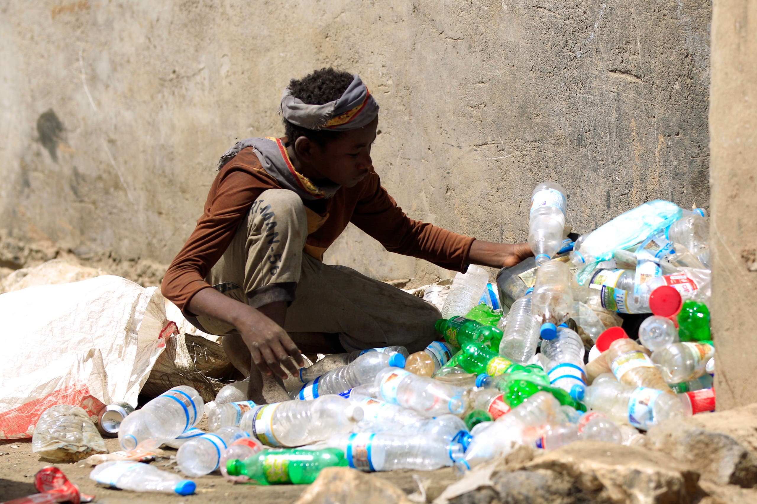طفل يجمع مخلفات البلاستيك في أحد شوارع صنعاء (أرشيفية)