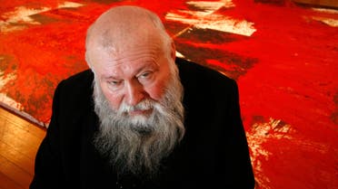 Austrian-born artist Hermann Nitsch poses in front of his painting made during a perfomance in 1996, at his retrospective 'Theatre of Orgies and Mysteries' at Berlin's Martin-Gropius-Bart art gallery December 1, 2006. The retrospective exhibition which shows part of Nitsch's work runs till January 22, 2007. REUTERS/Fabrizio Bensch (GERMANY)