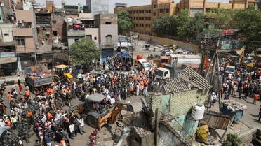 Police officials and members of security forces oversee the demolition of small illegal retail shops by civic authorities in a communally sensitive area in Jahangirpuri, in New Delhi, India, April 20, 2022. (Reuters)