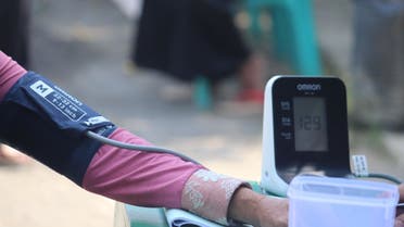 Stock image of a woman checking her blood pressure. (Unsplash, Mufid Majnun)