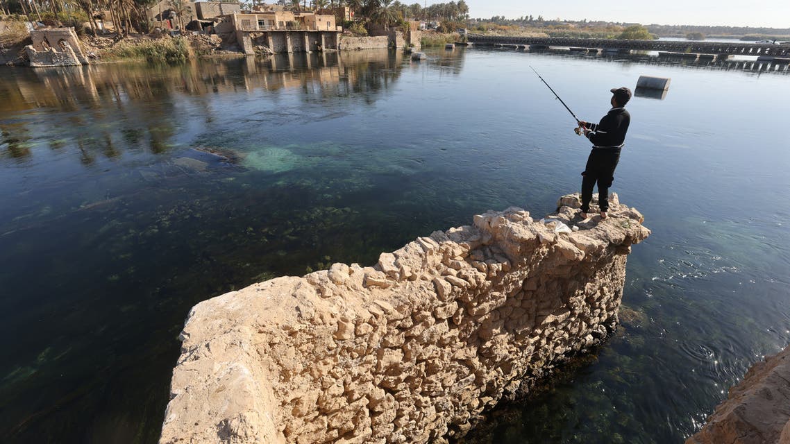 A man fishes in the Euphrates River in the city of Haditha in Iraq's central Anbar Governorate on December 22, 2021. (Photo by AHMAD AL-RUBAYE / AFP)