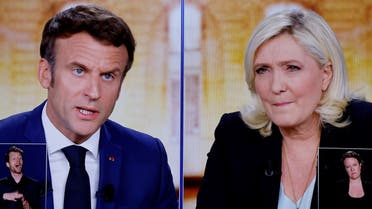 A picture shows screens displaying a live televised debate between French President and La Republique en Marche (LREM) party candidate for re-election Emmanuel Macron (L) and French far-right party Rassemblement National (RN) presidential candidate Marine Le Pen (R), broadcasted om French TV channels TF1 and France 2, in a viewing room at the studios hosting the debate in Saint-Denis, north of Paris, ahead of the second round of France's presidential election. (AFP)