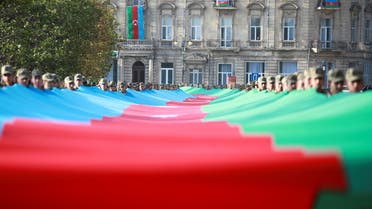 Azeri service members carry a giant flag during a procession marking the anniversary of the end of the 2020 military conflict over Nagorno-Karabakh breakaway region, involving Azerbaijan's troops against ethnic Armenian forces, in Baku, Azerbaijan, November 8, 2021. (File photo: Reuters)