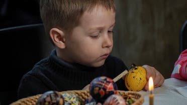 A boy paints an Easter egg in the traditional style during a lesson for children of families fleeing from Russia’s invasion of Ukraine, in central Kyiv, April 22, 2022. (Reuters)