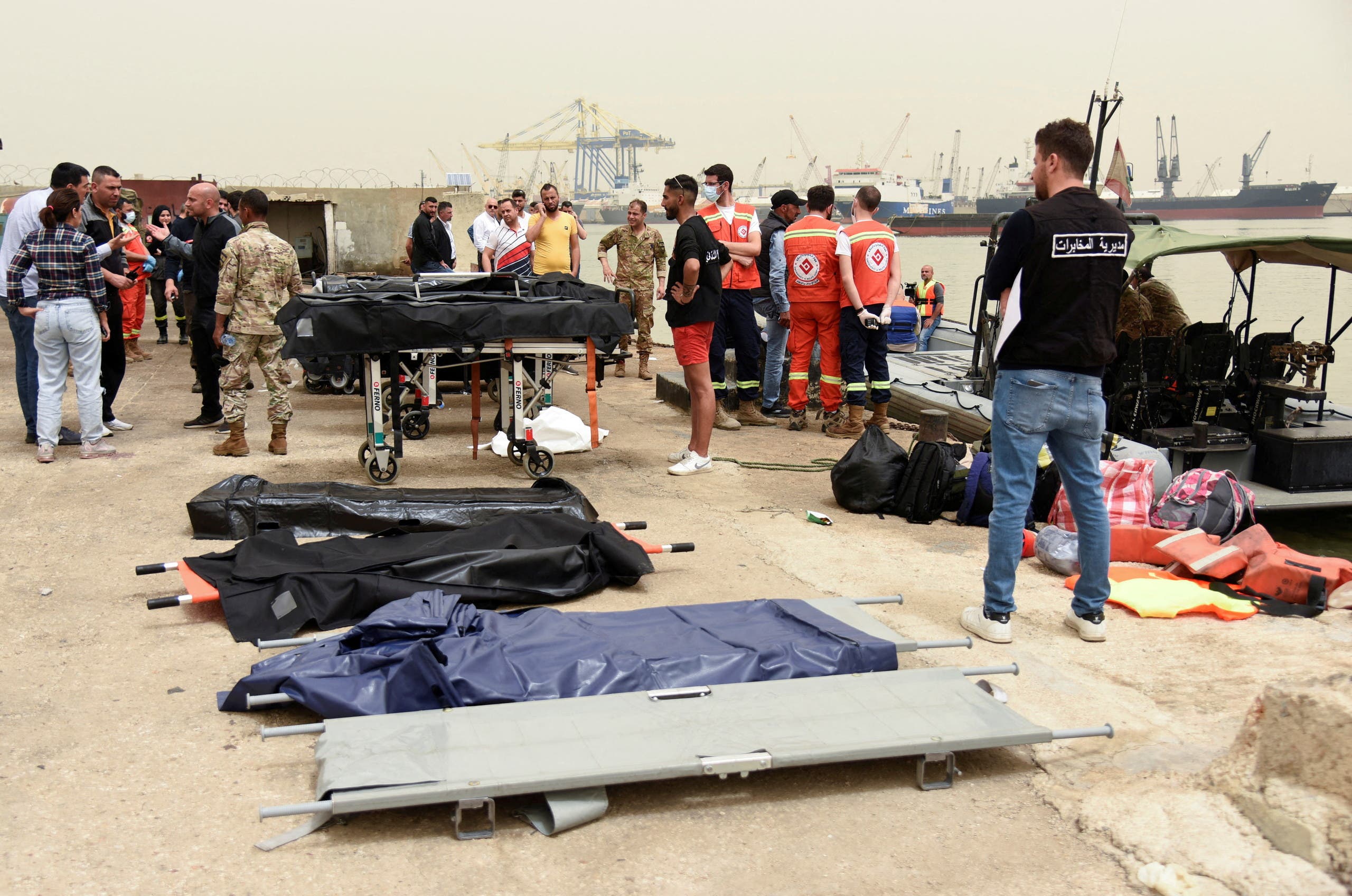 People stand near stretchers that are prepared for dead bodies after a boat capsized off the Lebanese coast of Tripoli overnight, at port of Tripoli, northern Lebanon April 24, 2022. (File photo: Reuters)