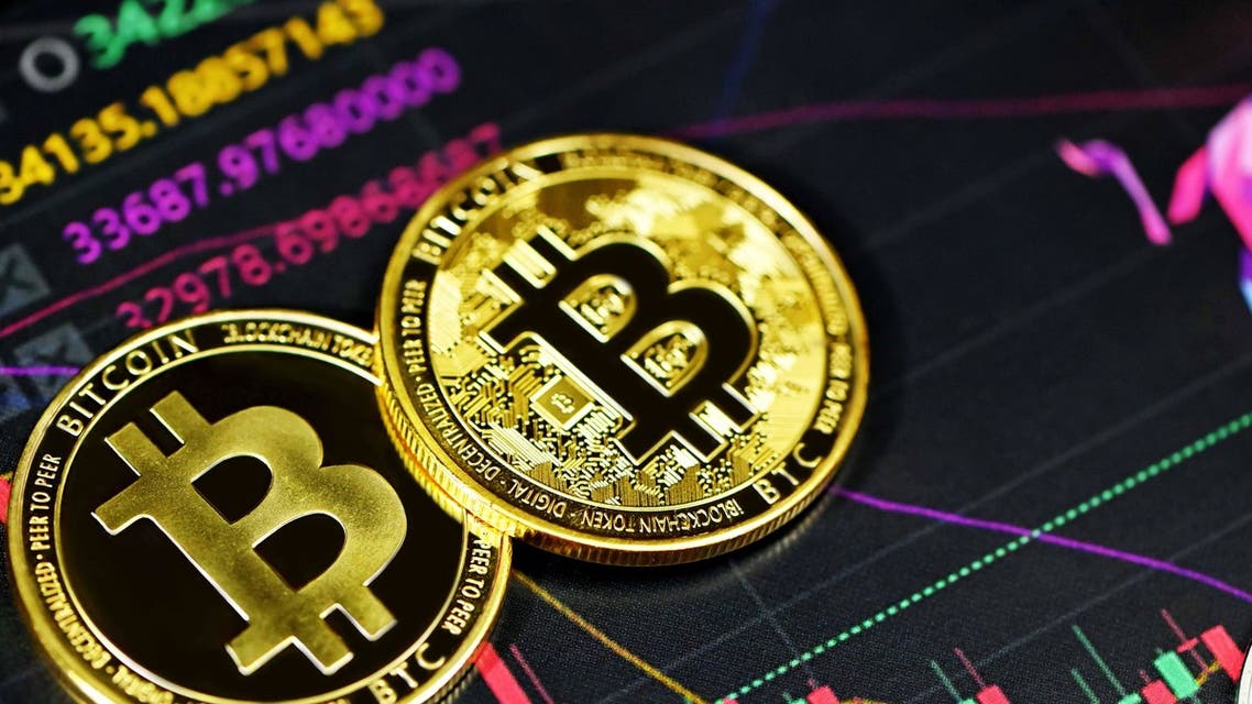 Two bitcoins against a backdrop of a trading chart. (Unsplash, Kanchanara)